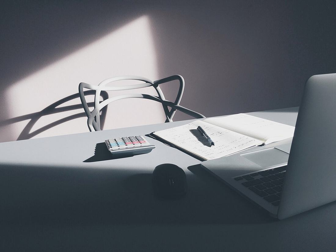 A desk with a laptop and a calculator